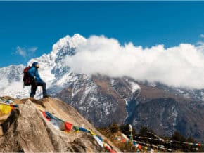Trekker on a hill in Nepal looking at the Himilaya Mountains