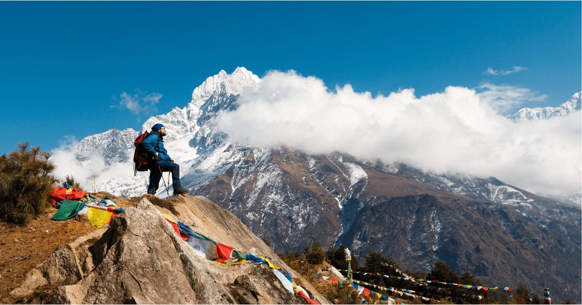 Trekker on a hill in Nepal looking at the Himilaya Mountains