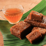 A cup of tea with Indonesian rice cakes on a banana leaf 