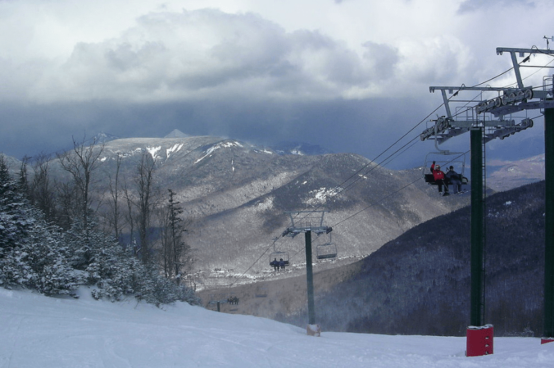 Ski lifts at Loon Mountain Ski Resort in New Hampshire's White Mountains. Mountains and clouds in background