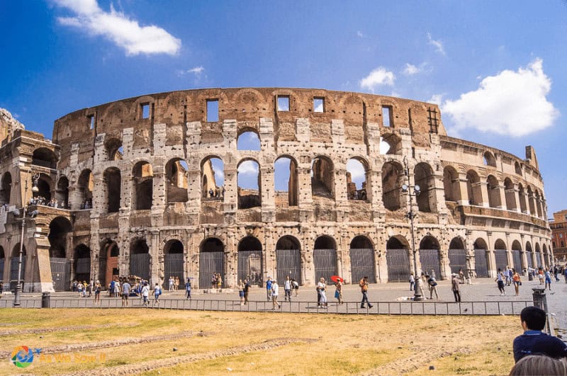Grassy lawn in foreground, Roman Colosseum in the background