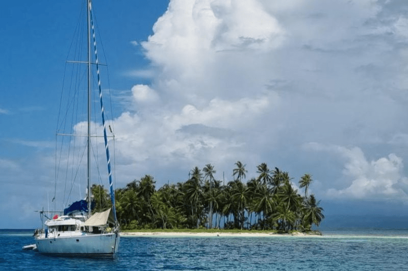 sailboat in front of an island in San Blas Panama