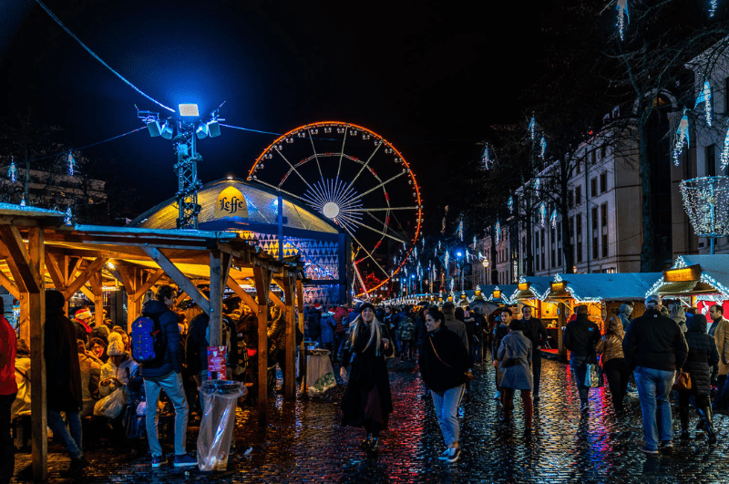 People enjoying a Christmas market in Brussels Belgium after dark