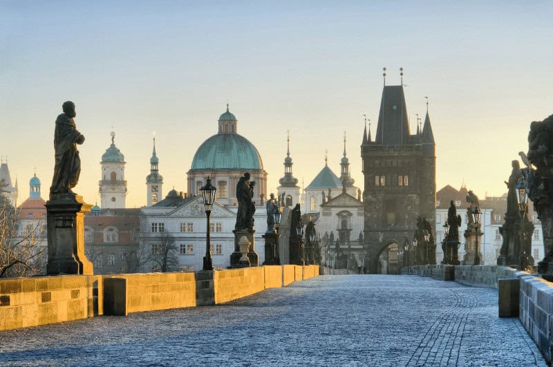 Statues and tower of Charles Bridge at dawn