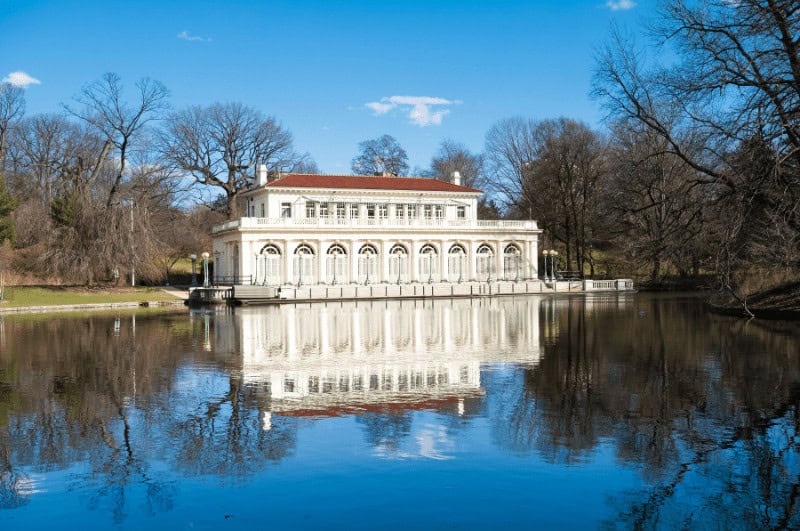 One of the best NYC parks, Prospect Park has an antique boathouse. Here it's reflected in a lake.