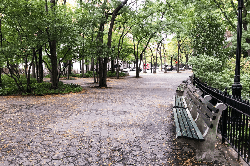 Sidewalk and park benches on a tree-lined path in Riverside Park, Upper West Side of Manhattan