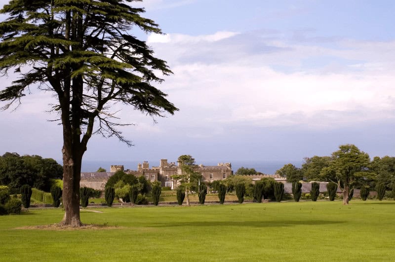 Ardgillan Castle with tree in foreground and water in the background