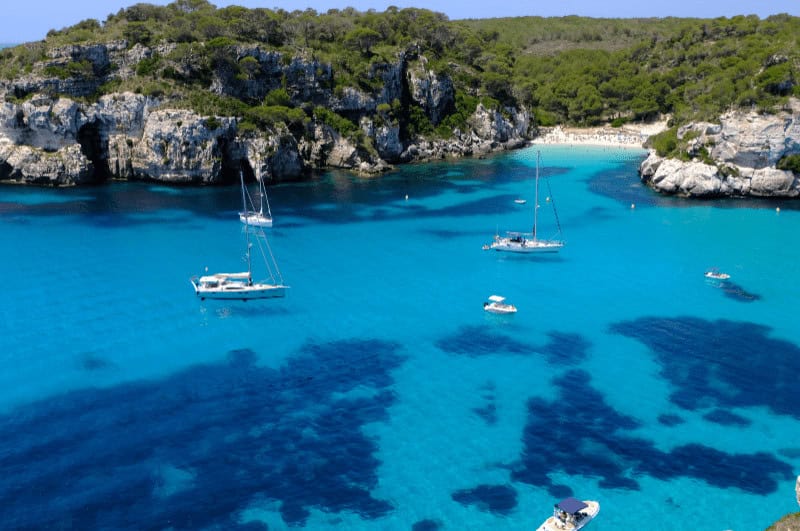 boats on the clear water in Menorca