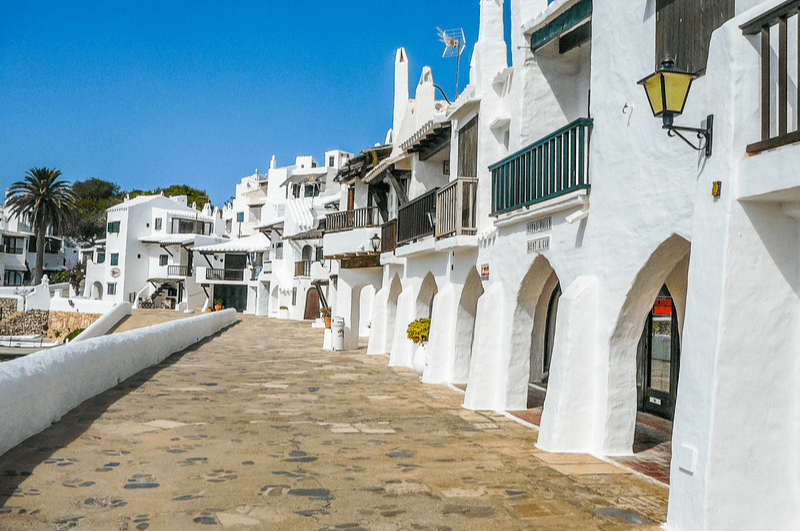 White stucco buildings along a walkway in Menorca