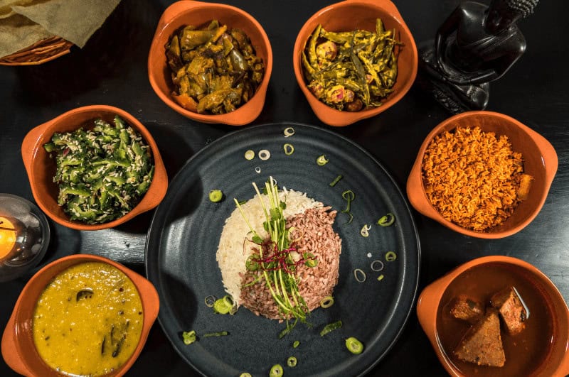 Dishes of Sinhalese food surrounding a plate of rice