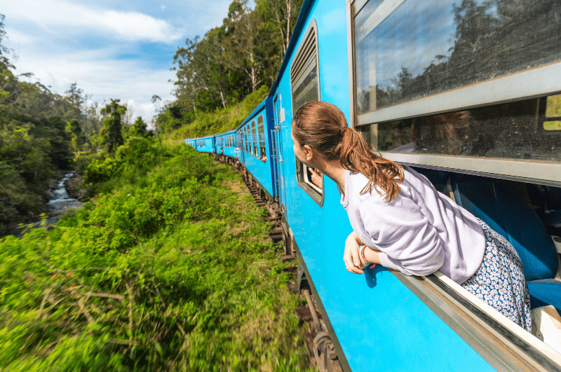 woman sticking her head out of the window on a train in Sri Lanka