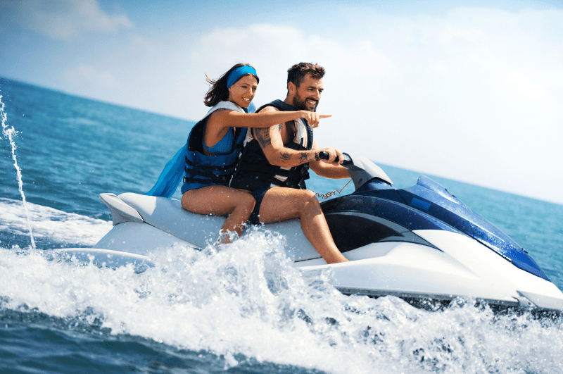 Couple on a jetski, with woman pointing in the distance