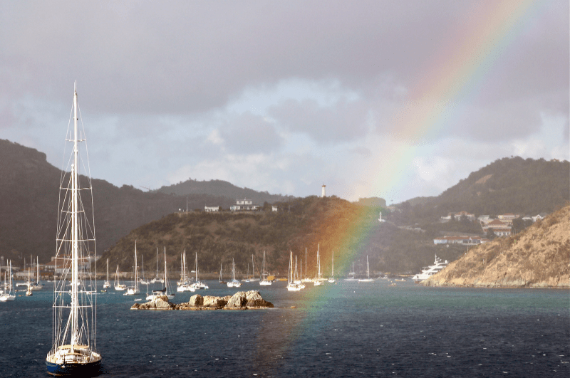 Rainbow in front of the harbor for the town of Gustavia hills in the background.