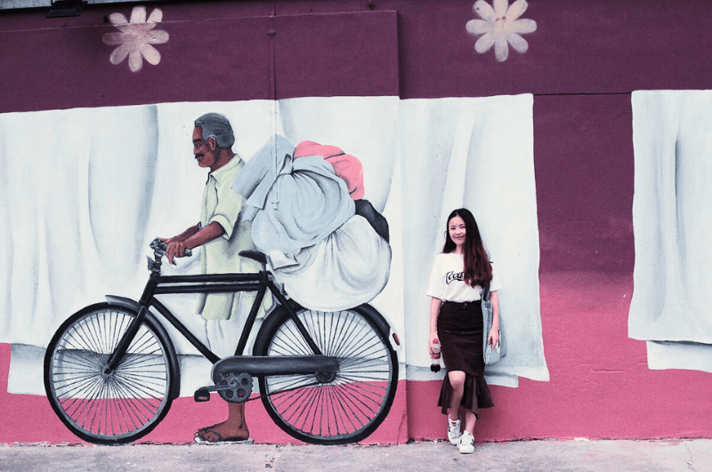 Woman posing next to a graffitied wall in Little India