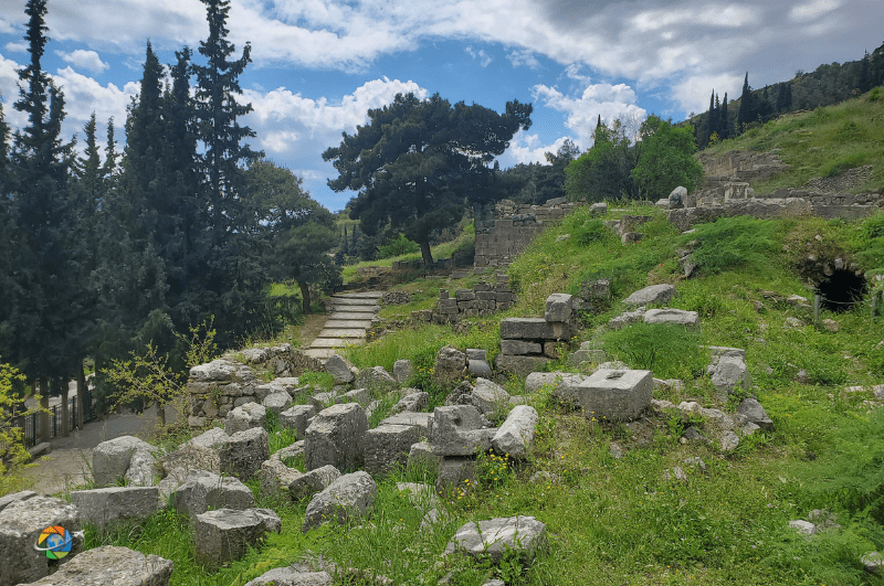 Path leading through trees and surrounded by the ruins of Delphi Greece