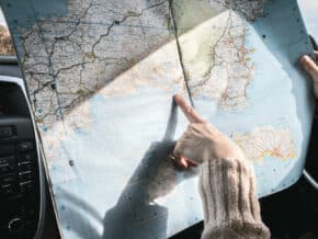 Hand pointing to a spot on a map of Europe