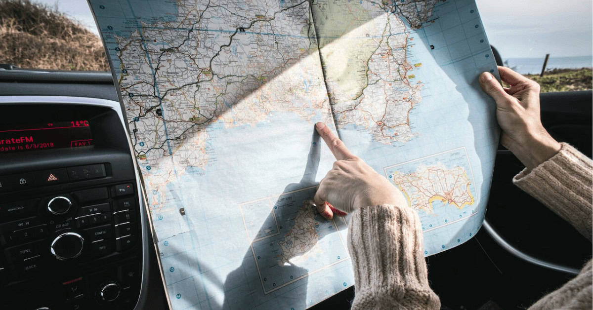 Hand pointing to a spot on a map of Europe