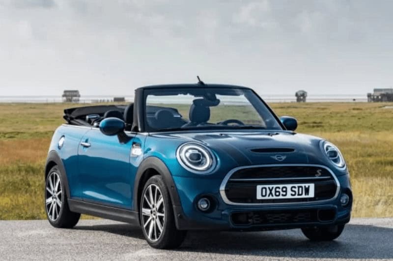 A blue Mini Cooper Convertible on a road trip in Europe