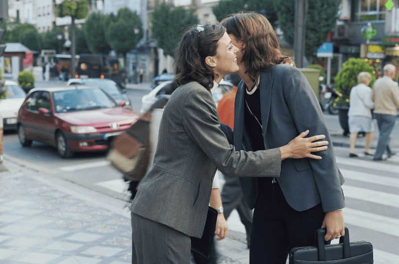 Women greeting each other with an air kiss