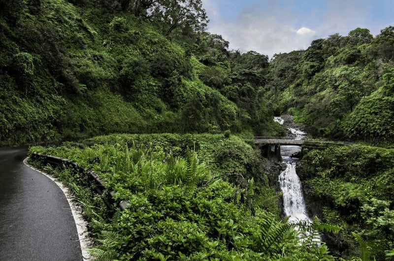 Winding road passing over a waterfall on the Hana Highway, aka the Road to Hana.