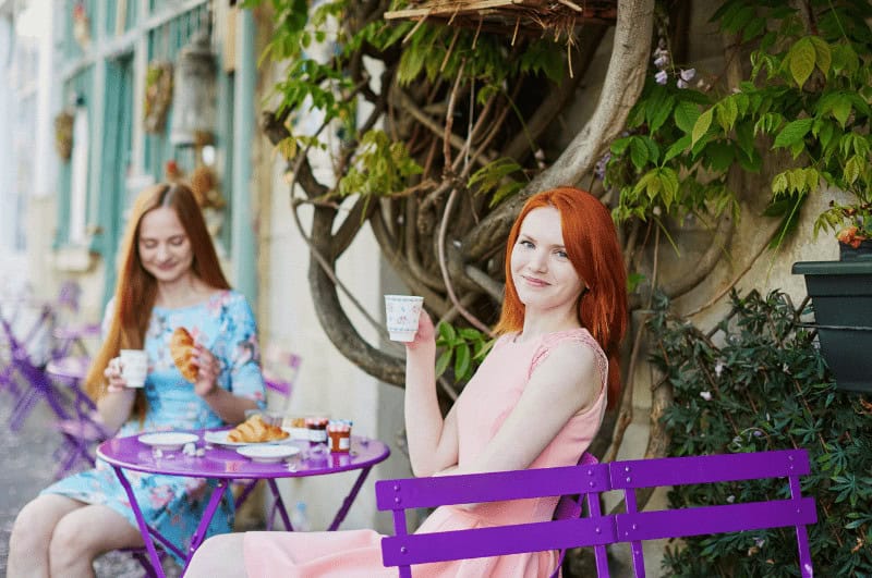 Two women drinking coffee at a bistro