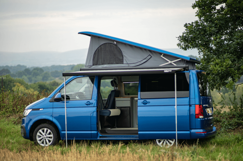 Volkswagen Transporter Camper Van with popup and side awning set up. One of the best vehicles for campers on a European road trip adventure