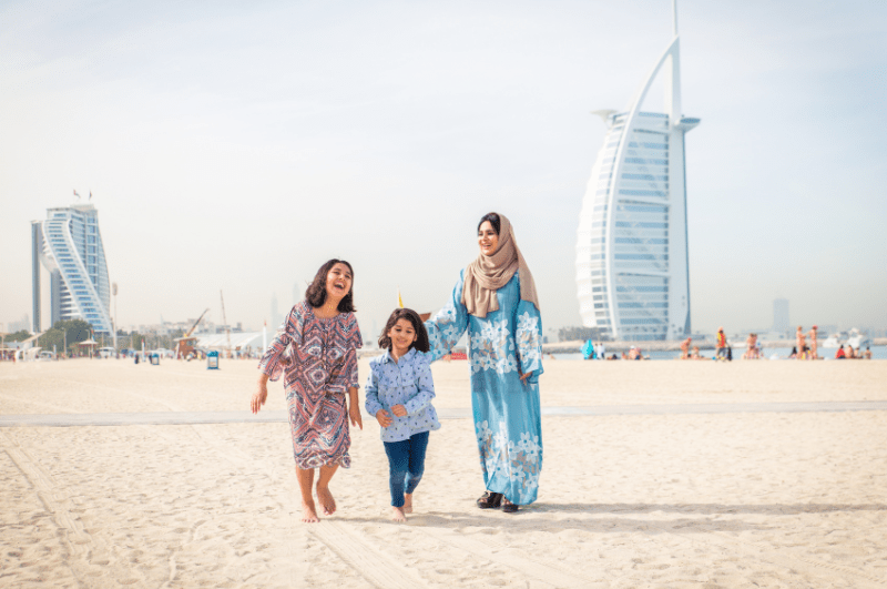 Two women with a little girl on the beach. One of the free things to do in Dubai with kids