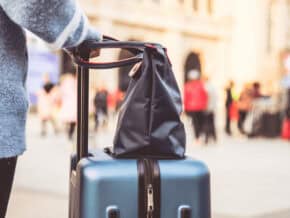 closeup of suitcase and woman's purse on a city break packing list