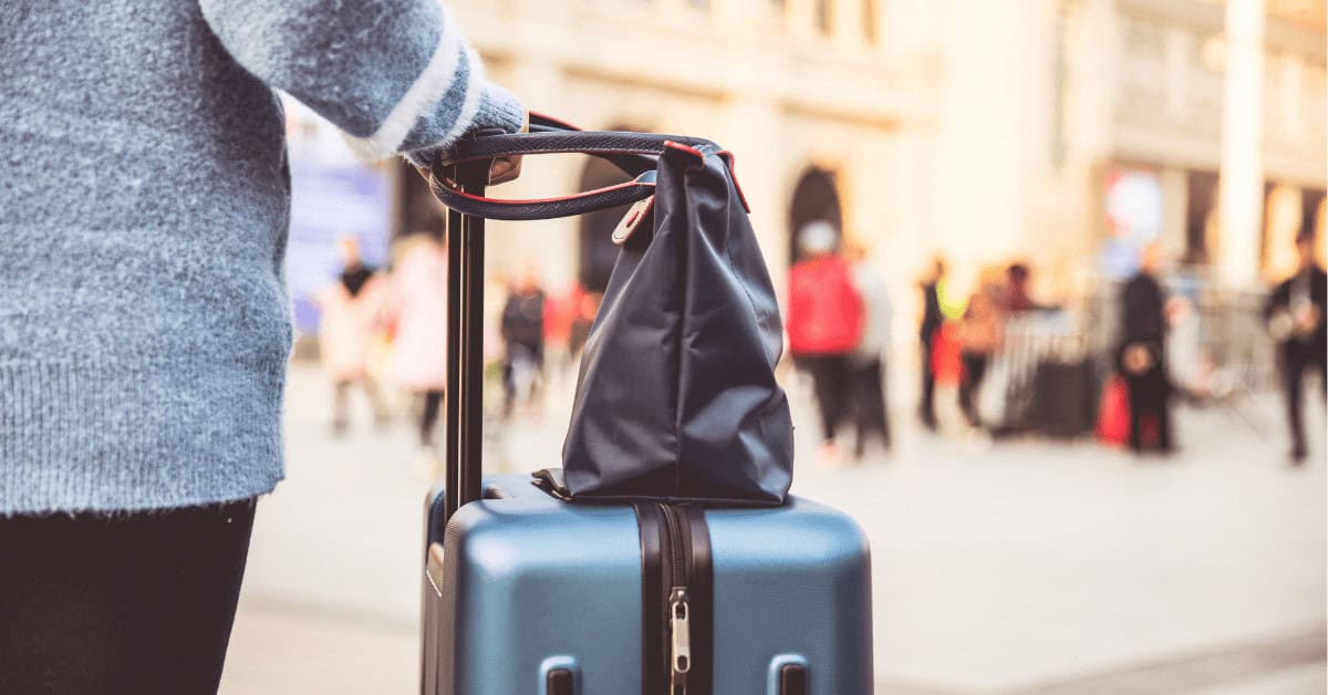 closeup of suitcase and woman's purse on a city break packing list