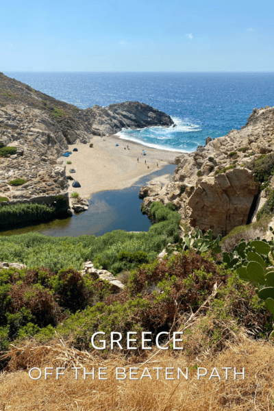 A beach on a Greek island as seen from a hilltop. The text overlay says "Greece off the beaten path"