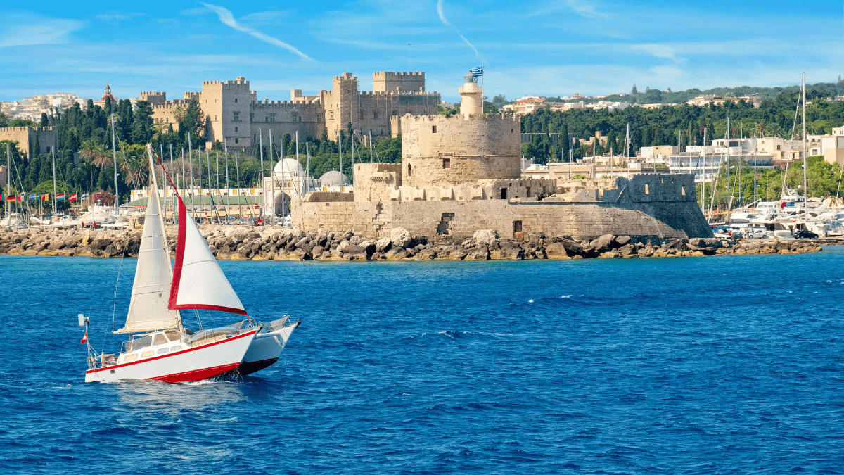 Rhodes itinerary 7 days: sailboat on the water and a fortress in the background