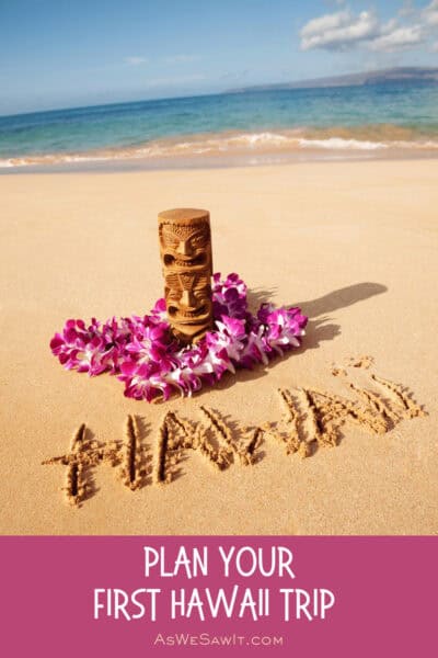 Tiki and lei on a beach, with the word Hawaii carved into the sand. Text overlay says "Plan Your First Hawaii Trip" As we saw it dot com