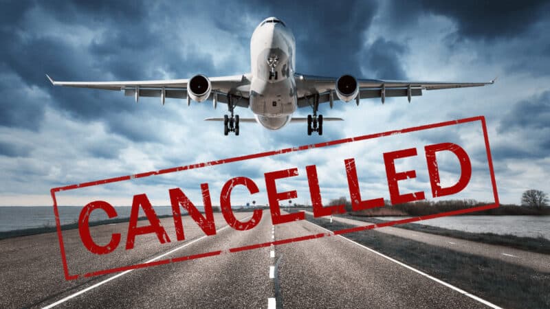 A plane landing on a runway. The word Cancelled is written across the image as a banner.