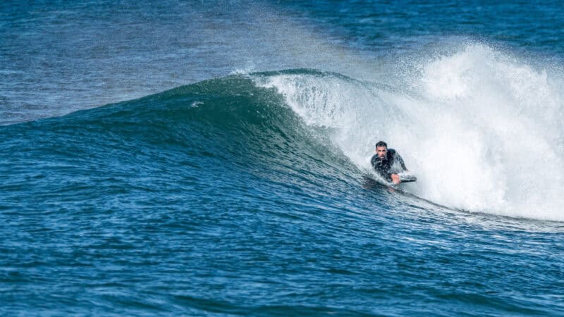A person bodyboarding on a small wave