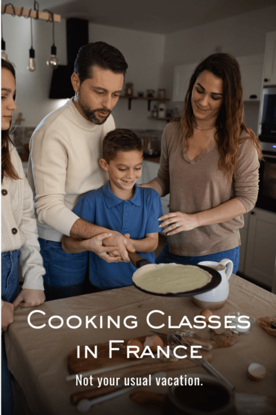 Chef and mom behind a boy holding a crepe pan. The text overlay says :Cooking classes in France: not your usual vacation."