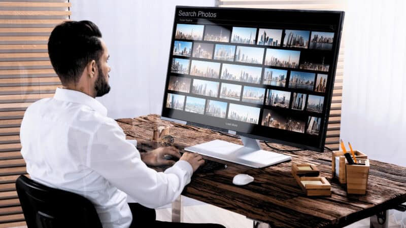 Man working on photos on a large computer screen