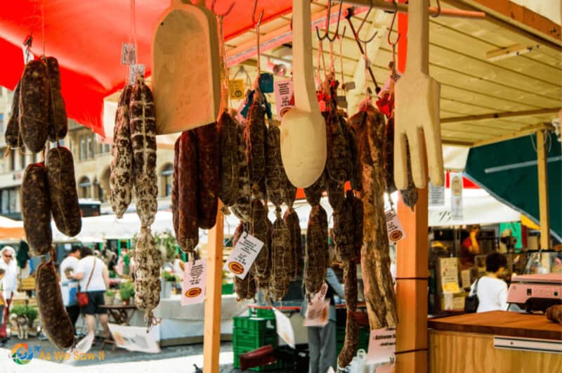 Sausages and cheeses hanging in a market stall in Basel town square