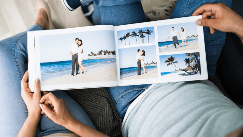 A travel photo book on someone's knees