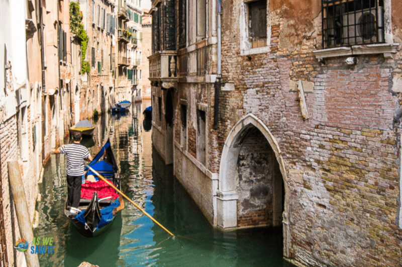 Gondolier in Venice boating in a hidden canal