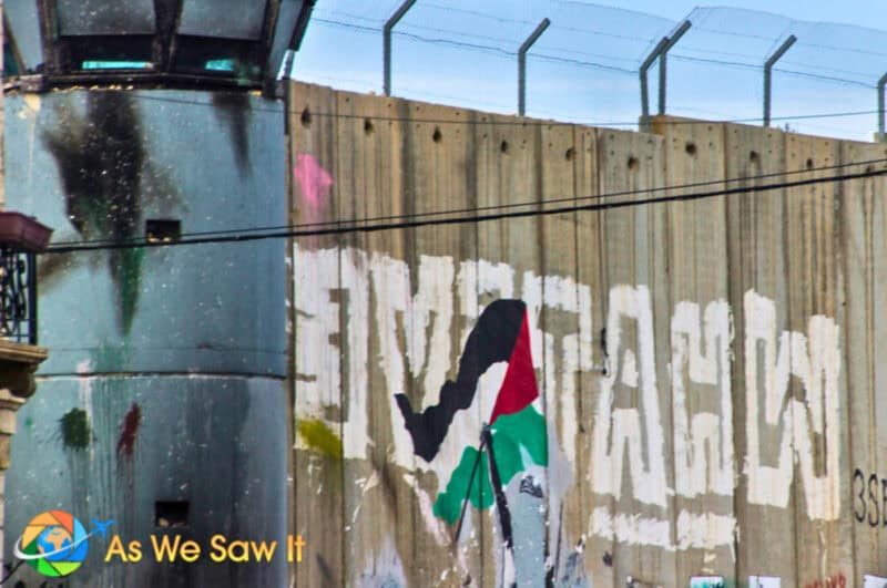 Graffiti on the separation wall behind an Israeli security tower.