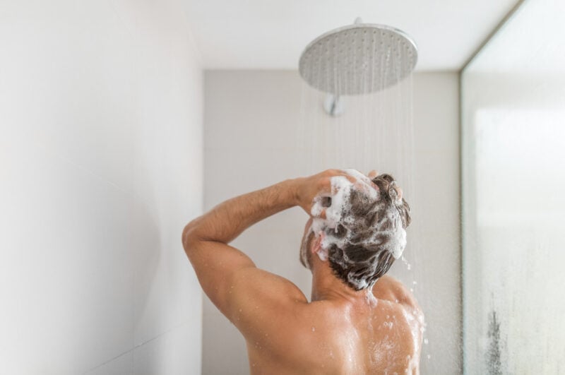 A man washing his hair in a shower