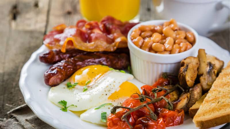 Full English breakfast enjoyed on the London foodie itinerary—eggs, bacon, beans, and toast served on a rustic table.