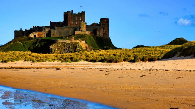 Bamburgh Castle above the beach on Northumberland’s coast