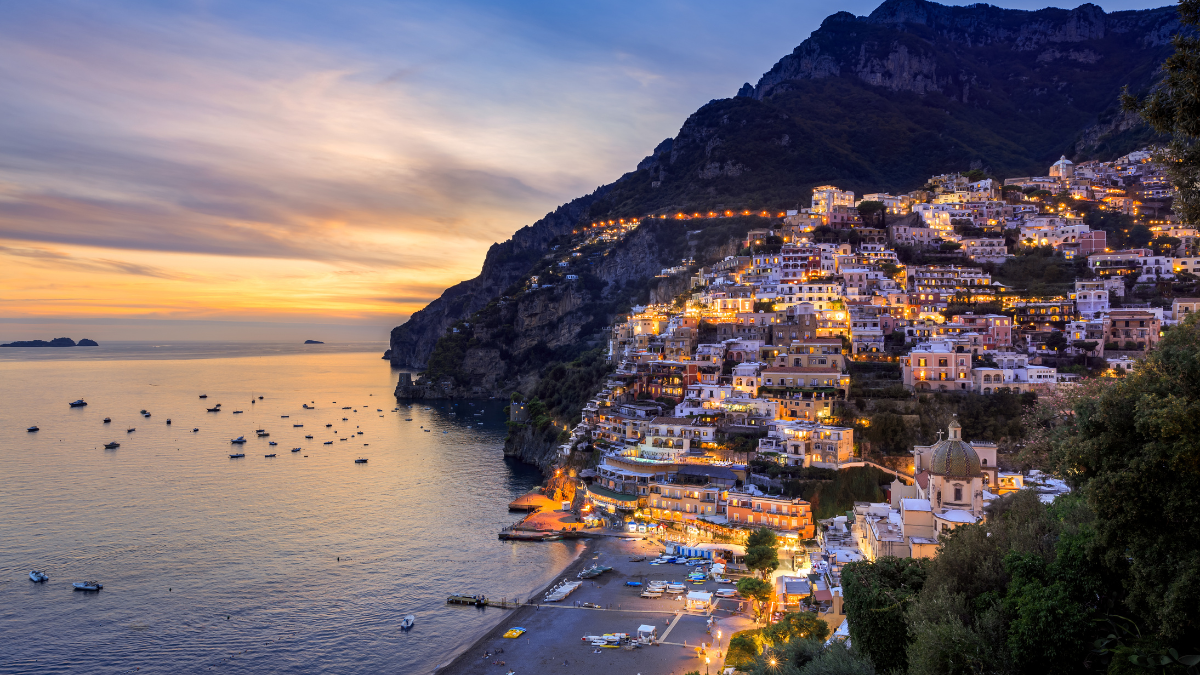 Sunset view of Positano’s steep cliffside buildings along the Amalfi Coast
