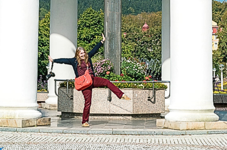 Linda sightseeing in Czechia with a red crossbody bag