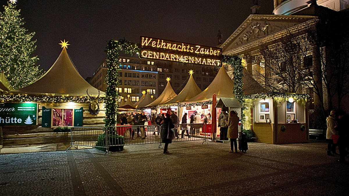 WeihnachtsZauber Christmas market entrance at Gendarmenmarkt in Berlin, Germany, illuminated at night.