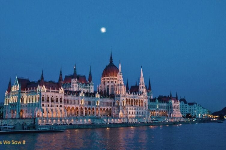 Hungarian Parliament Building illuminated at night beside the Danube in Budapest