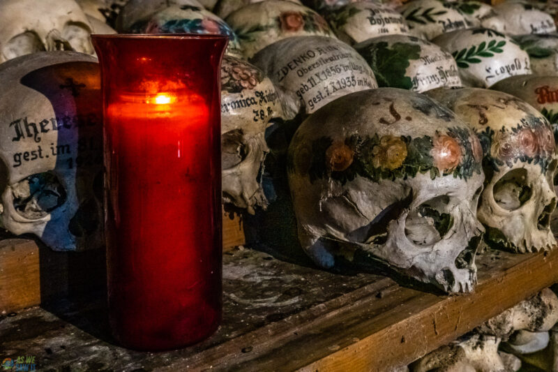 Painted skulls and red candle inside the Hallstatt Bonehouse