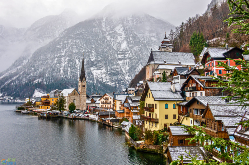 Hallstatt village and church beside Lake Hallstatt with snow-covered mountains in winter