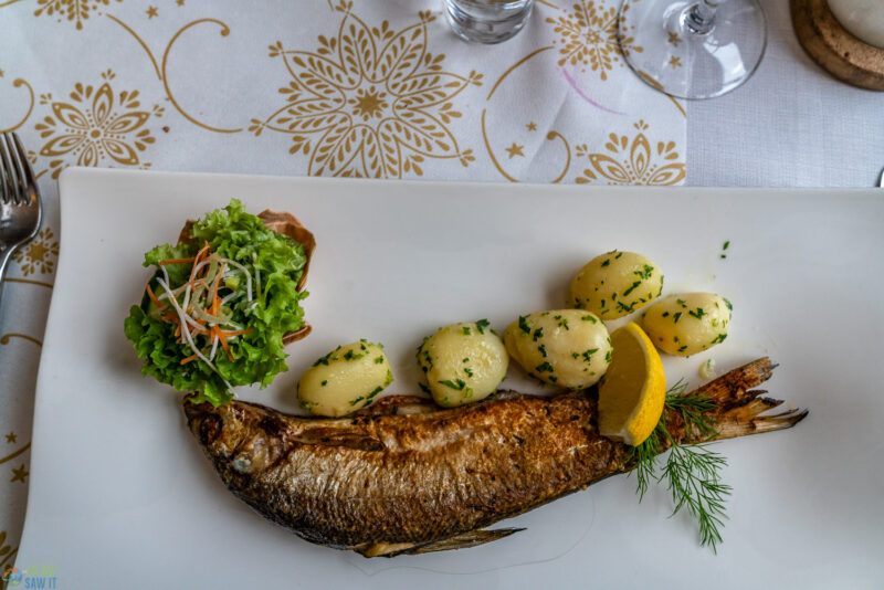 Whole local fish served with potatoes and salad in Hallstatt